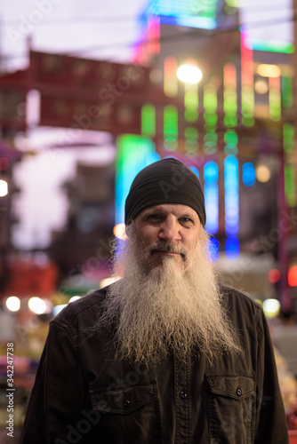 Mature tourist man with long beard in Chinatown at night