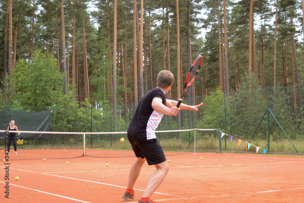 back view of a male tennis player with a racket waiting for a pass from the opponent