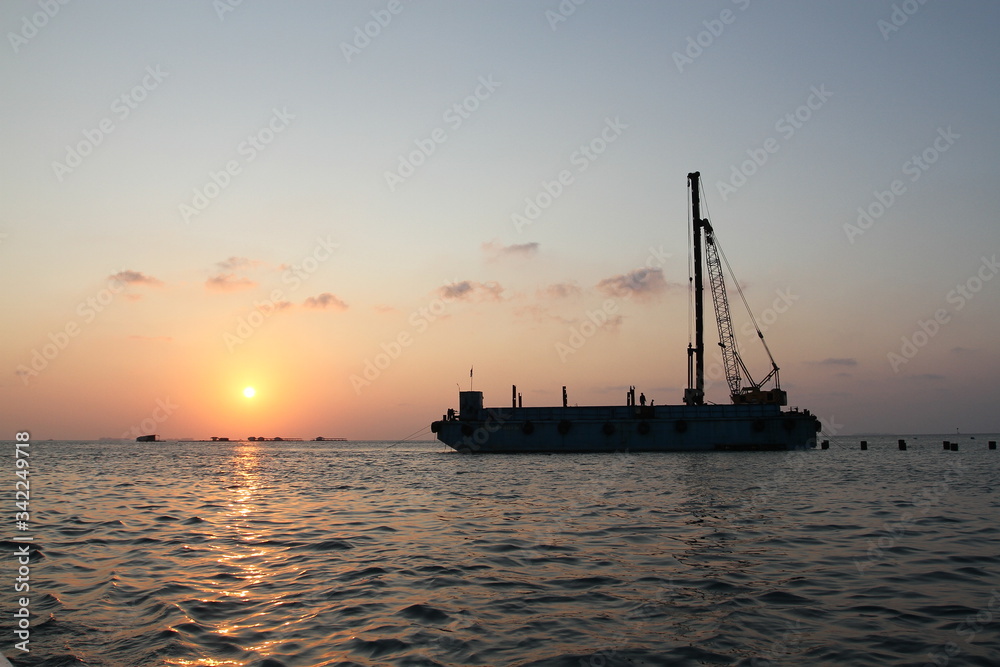 sunset in the harbor. crane vessel silhouette