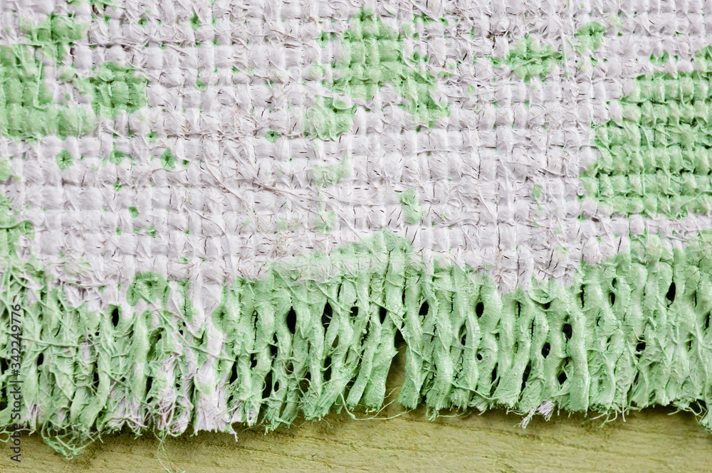 Closeup texture of a roughly painted white and light green canvas lying on a wooden surface. Background for fabric texture. Universal background. Closeup texture of a roughly painted white and light green canvas lying on a wooden surface. Background for fabric texture. Universal background.