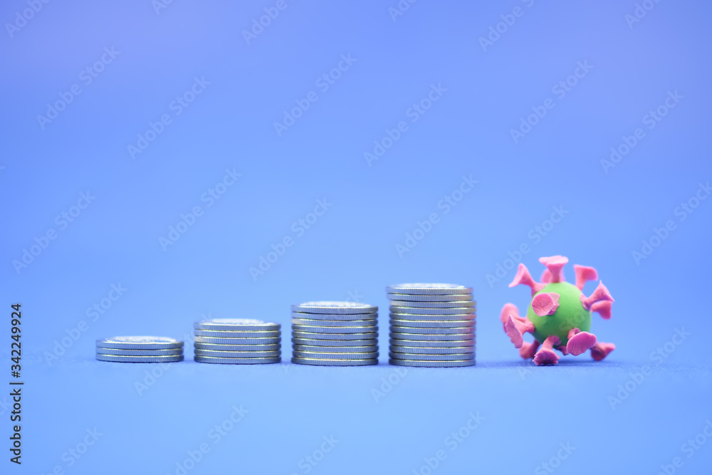 Money, Financial,Saving, Business Growth concept, Closeup of stack of coins and mini corona virus ball on blue background and copy space for text. Money, Financial,Saving, Business Growth concept, Closeup of stack of coins and mini corona virus ball on blue background and copy space for text.