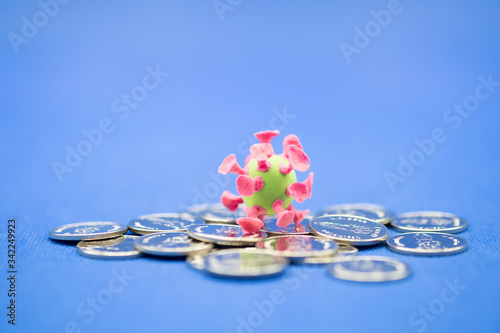 Money, Financial,Saving, Business, Closeup of mini corona virus ball on coins and blue background with copy space for text.
