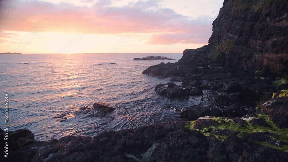 The beautiful, romantic view of the sunset over the Antrim Coast shoreline in Ireland - wide shot The beautiful, romantic view of the sunset over the Antrim Coast shoreline in Ireland - wide shot