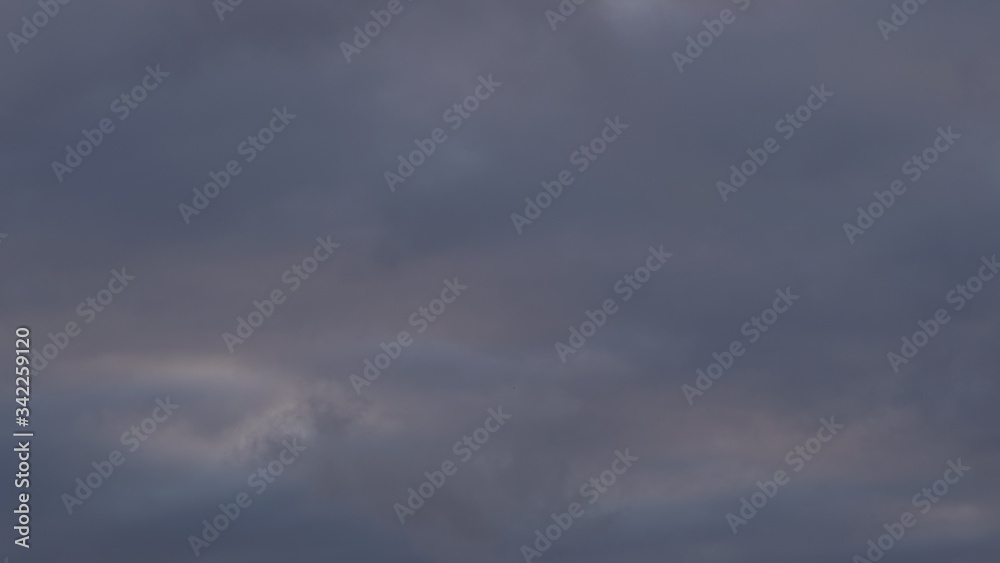 A beautiful evening blue sky at sunset with flaming bright light clouds. Warm evening.