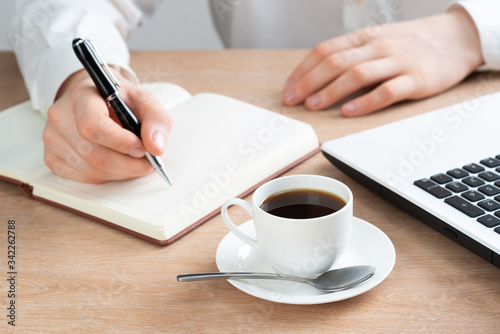 Close-up of male hand writing in notebook