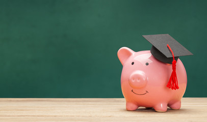 Piggy bank and black graduate hat isolated on white background. Green school board background