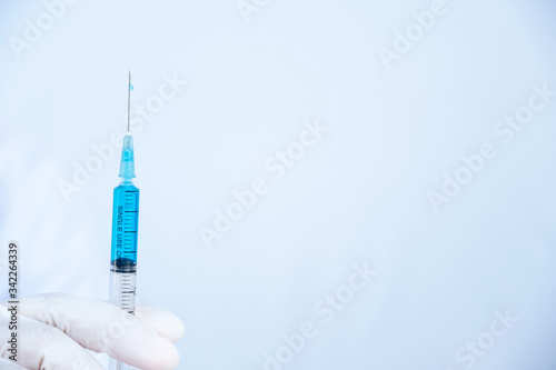 The picture of doctor's hand holding syringe