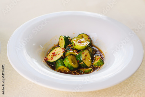 cucumbers in sauce on a white plate