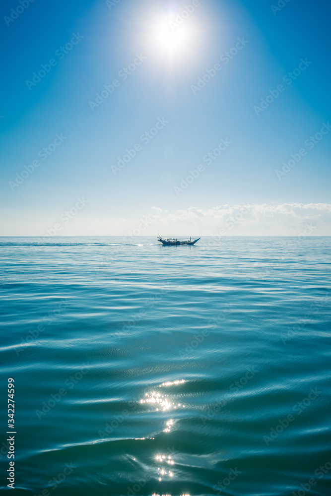 Naklejka premium Boat sailing in the sun through the Arabigo Sea in the direction of Masirah Island, Oman