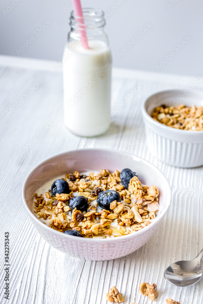 Homemade fitness granola with yoghurt and berries on white kitchen background Homemade fitness granola with yoghurt and berries on white kitchen background