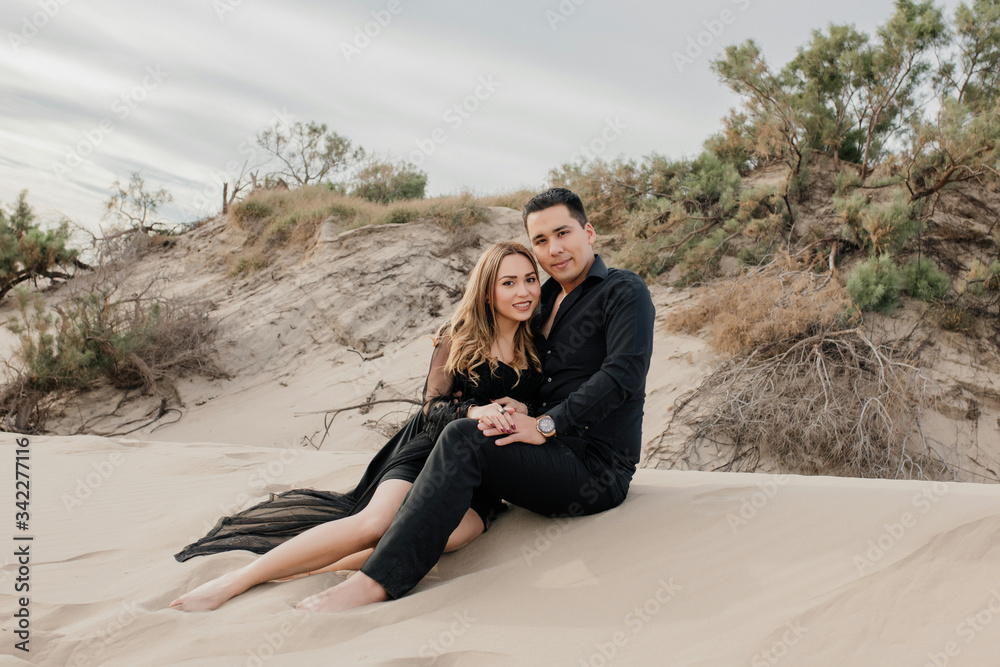 Young attractive couple sitting on the sand posing holding each other
Black formal shirt and pants Young attractive couple sitting on the sand posing holding each other
Black formal shirt and pants