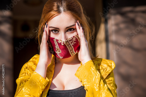 Young woman in fashionable homemade mask, scarf on her face, stop virus, save yourself, modern lifestyle
