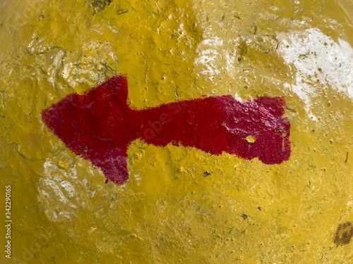 A left pointing red arrow on a yellow background.