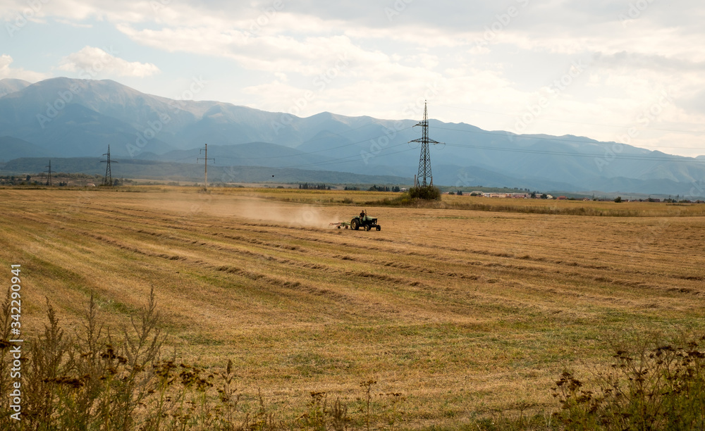 a man on a tractor working the field work