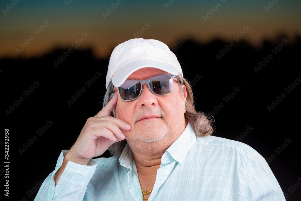 Man portrait outside during dusk hours. The horizon serves as background. He has a smile and is looking to the camera. Man portrait outside during dusk hours. The horizon serves as background. He has a smile and is looking to the camera.