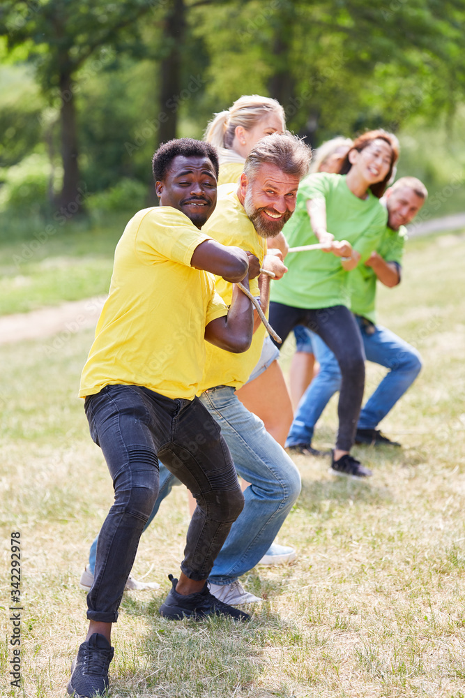 Fototapeta premium Zwei fröhliche Teams beim Tauziehen mit Seil