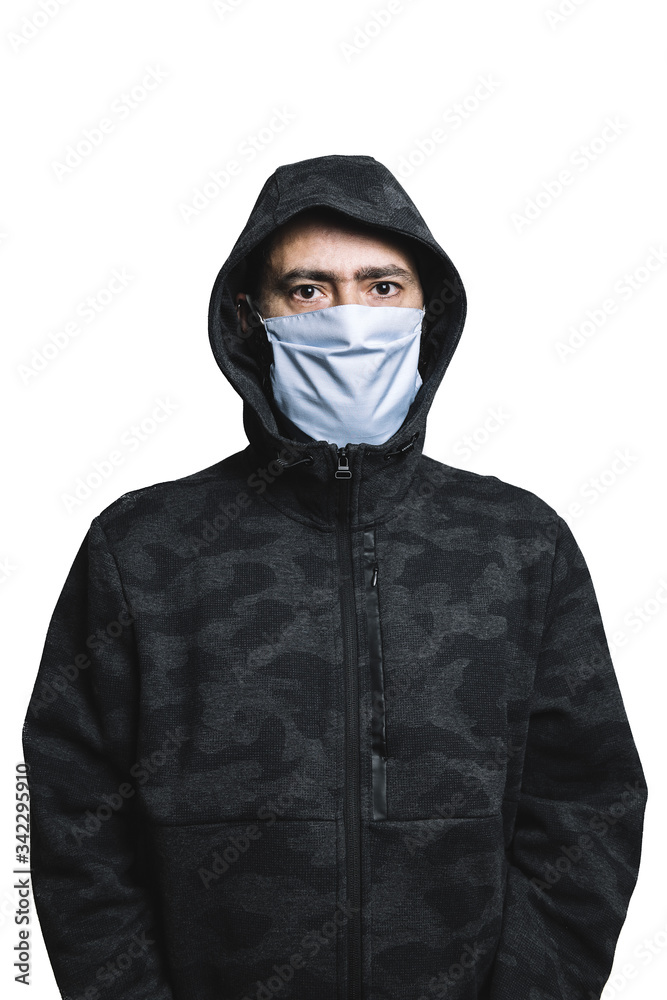 man with protective mask and hoodie looking at camera, concept of social distancing by the crisis of the coronavirus pandemic