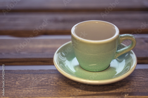 Colorful ceramic cup on wooden table for espresso