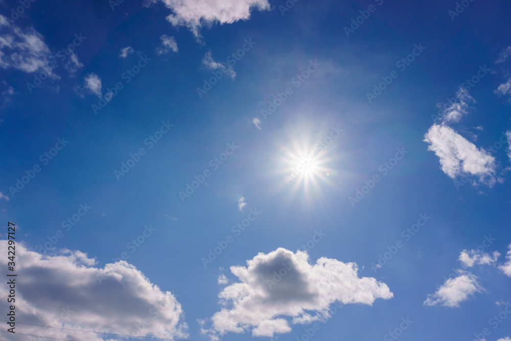 White fluffy clouds floating in the blue summer sky. Cloudy serene landscape.