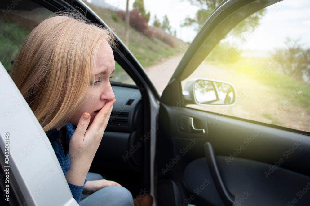 Nausea during a car trip. A blonde woman suffers from kinetosis. The concept of motion sickness in diseases of the transport and vestibular apparatus