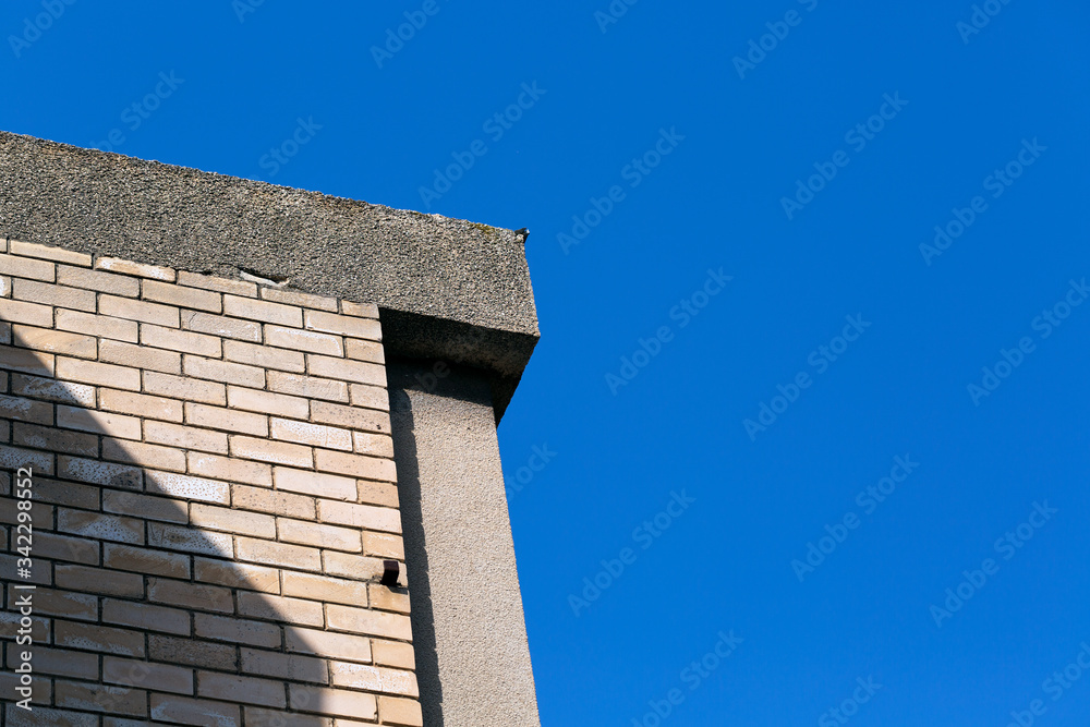 Upwards view of modern concrete buildings against a beautiful blue sky.
Upwards view of modern concrete buildings against a beautiful blue sky.