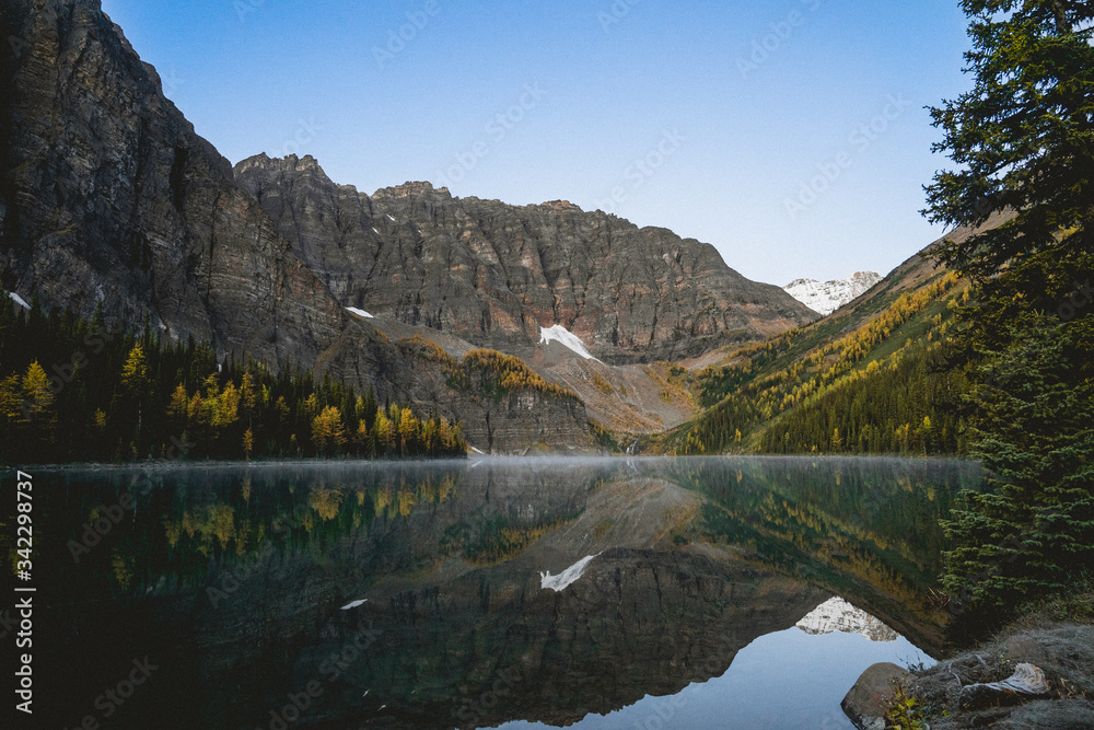 Obraz premium still lake in a mountain valley on a fall day