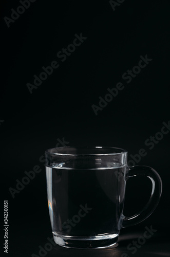 Glass with water on a black background. Cup of water.