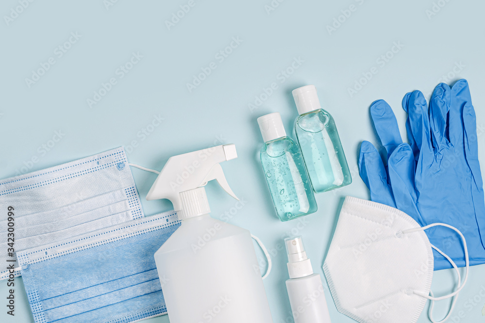 White medical masks and respirators with glove, hand sanitizer on blue background. Face mask protection KN95 or N95 and surgical masks for protection virus, flu, coronavirus, COVID-19. White medical masks and respirators with glove, hand sanitizer on blue background. Face mask protection KN95 or N95 and surgical masks for protection virus, flu, coronavirus, COVID-19.
