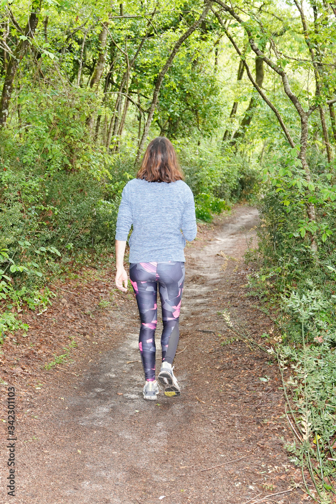 back jogging girl athlete runner feet running behind in natural park Woman fitness slim active lifestyle concept