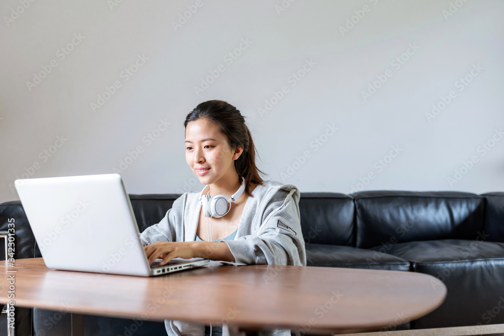 A young Asian woman in a sports office at home A young Asian woman in a sports office at home