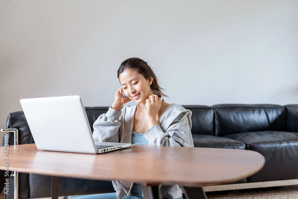 A young Asian woman in a sports office at home A young Asian woman in a sports office at home