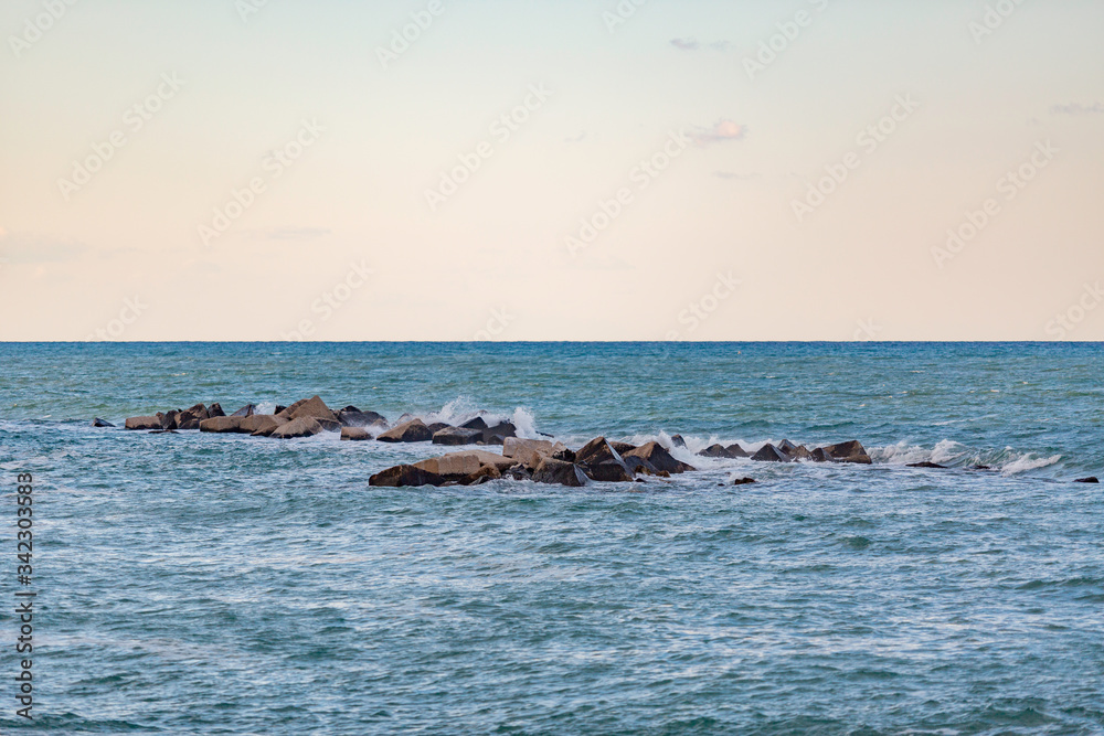Fototapeta premium Mare e scogli frangiflutti con piccoli spruzzi di mare