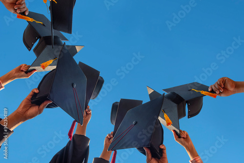 Принти на полотні Black hat of the graduates floating in the sky.