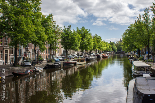 Fluss durch Amsterdam am einem warmen Sommertag mit typischen Booten