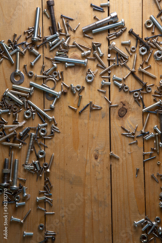 Many screws placed on a wooden table