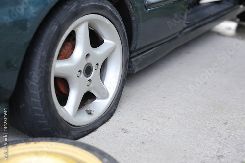 Wallpaper Mural Flat tyre on road. Car tire leak because of nail pounding. Wheel damage on a road. Torontodigital.ca