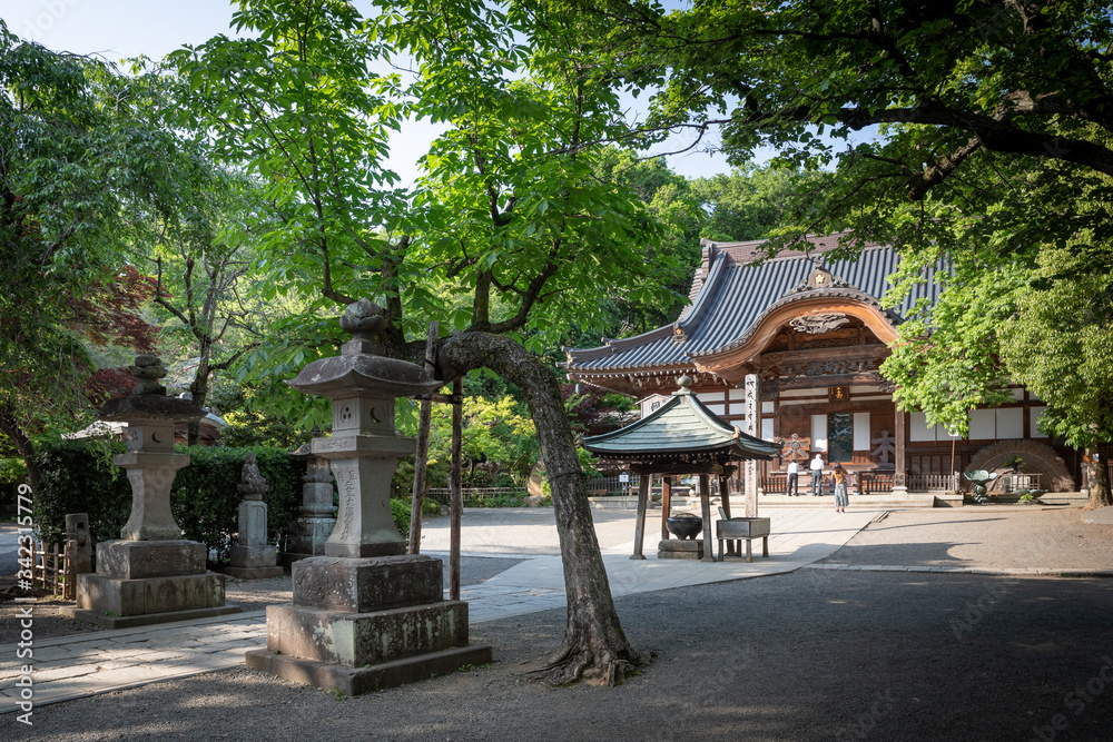 新緑の深大寺境内と本殿。石灯籠には元三大師の名があり。木の柱には「空、風、火、水、地」と梵字で書かれている。深大寺は東京調布市にある古い寺院。