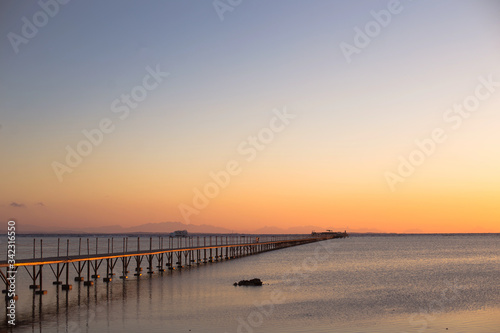 a wooden long bridge at the sea at orange sunset,backgound,texture,wallpaper, amazing romantic view, a path for a walk