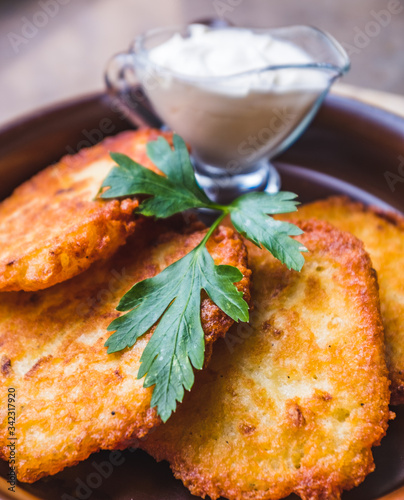 Fresh potato pancakes with sour cream served in a pan, traditional in Polish cuisine