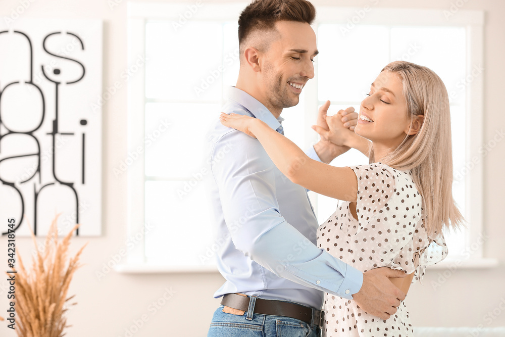 Happy dancing young couple at home