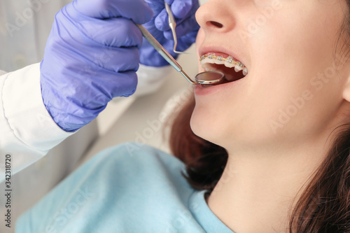 Teenage girl with dental braces visiting orthodontist in clinic