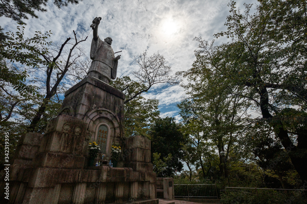 Fototapeta premium 池上本門寺の日蓮大上人説法像。太陽が入った斜めからの画。池上本門寺は東京都大田区にある鎌倉時代からの寺院。