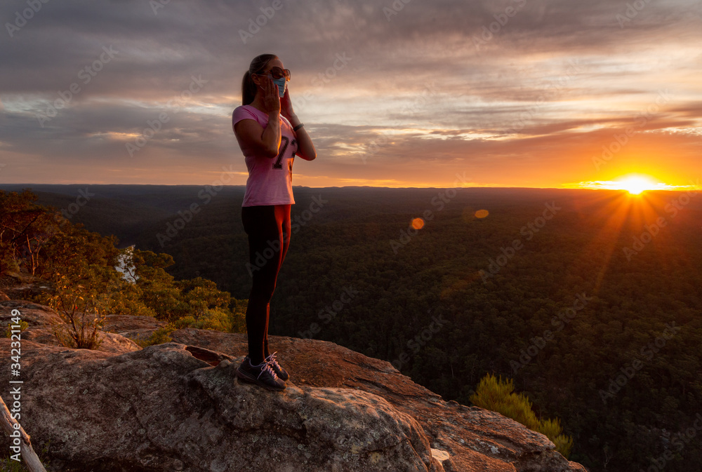 Athletic woman wearing a medical protection mask outdoors in nature sunset COVID-19 pandemic concept Athletic woman wearing a medical protection mask outdoors in nature sunset COVID-19 pandemic concept