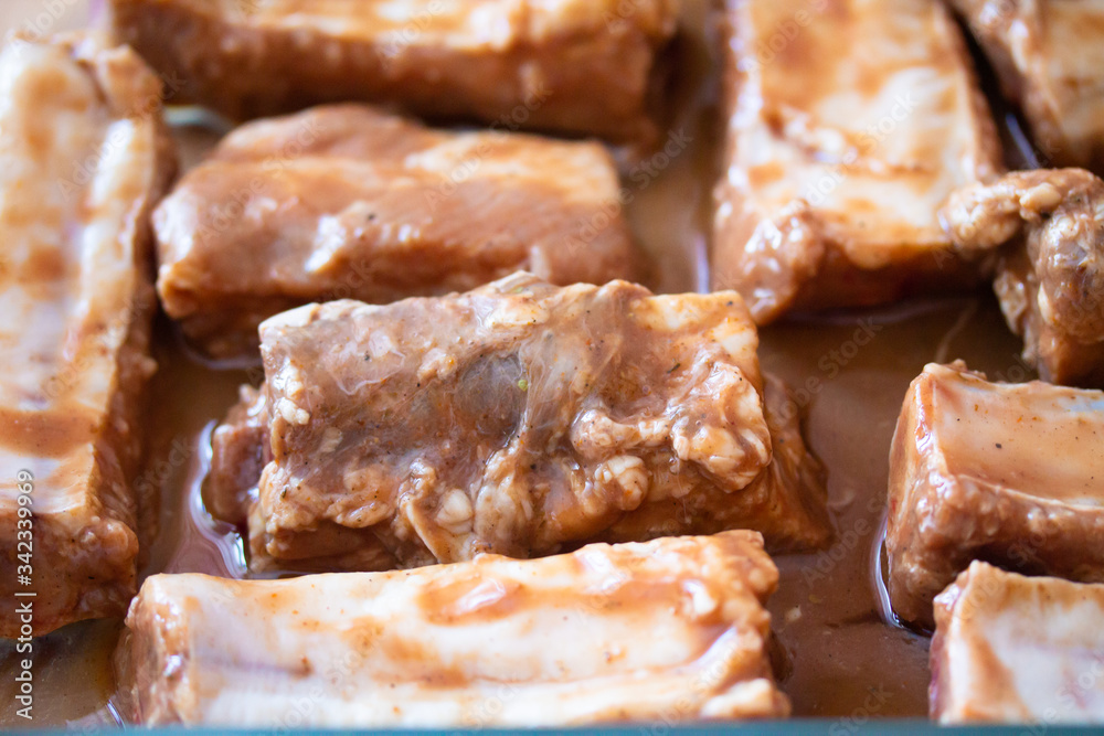 Raw marinaded juicy pork ribs ready for cooking. Meat processing picture. Food photography close up background Raw marinaded juicy pork ribs ready for cooking. Meat processing picture. Food photography close up background