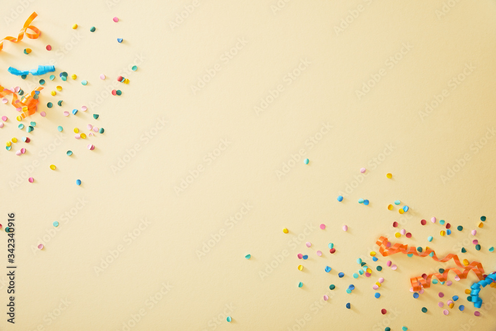 Top view of festive colorful confetti on beige background - obrazy, fototapety, plakaty 