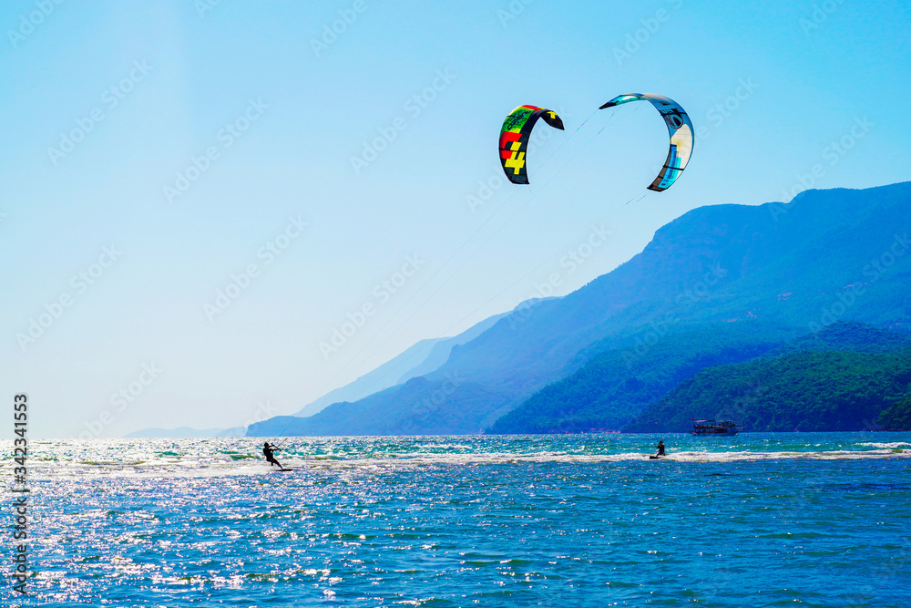 Akyaka, Mugla/Turkey-August 14 2018: Two surfers enjoying kite surfing at the beach where Azmak River meets the Mediterranean Sea