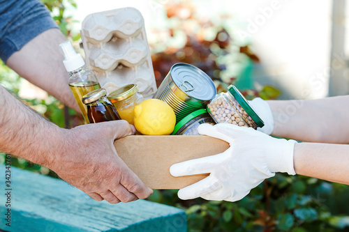 Volunteer passes a cardboard box with food