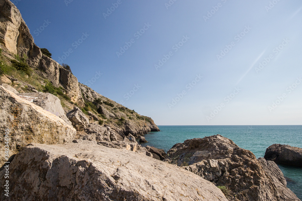 Fototapeta premium Travel in Crimea, Russia. Nature background. Colorful landscape with blue sea, mountains, rocks and sunlight in clear warm summer cloudless day. Concept of vacation on the coast