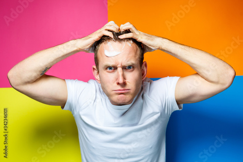Foto Portrait of a young, handsome, cheerful guy on a multi-colored background, dress