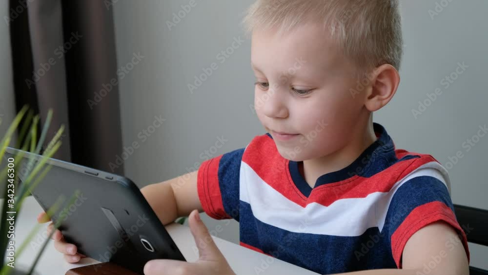 Cute school boy speaking with someone via voice call, learning on computer, distance education concept Cute school boy speaking with someone via voice call, learning on computer, distance education concept